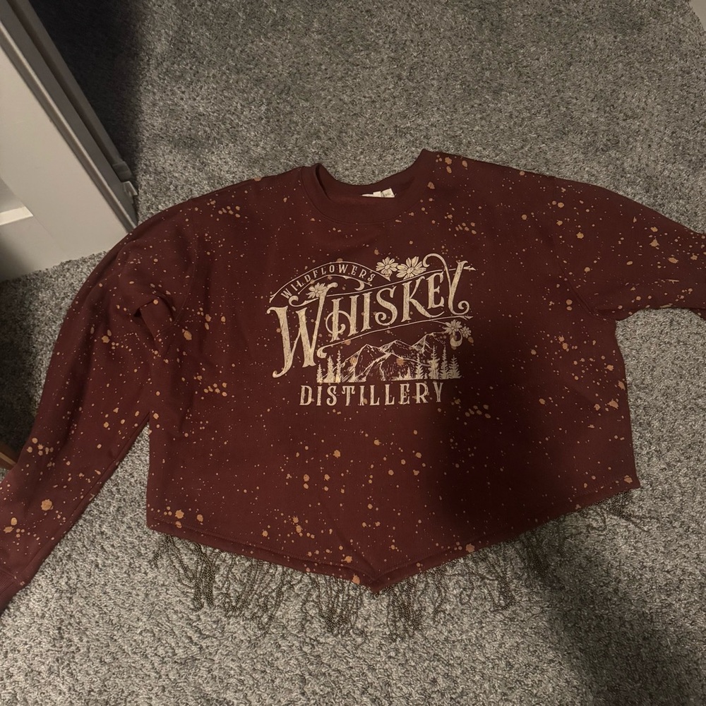 Little sweater top with dangling on the bottom.